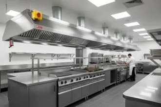 Hotte professionnelle en cuisine avec conduits d'évacuation et éclairage intégré