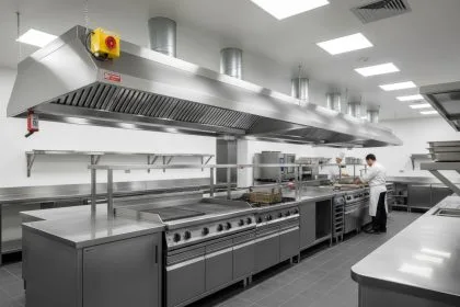 Hotte professionnelle en cuisine avec conduits d'évacuation et éclairage intégré